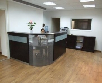 עמדת קבלה פינתית בשילוב רשת מתכת וזכוכית חלבית